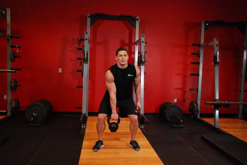 One-Arm Kettlebell Clean and Jerk, position 1 of 2