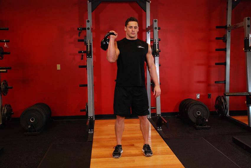 One-Arm Kettlebell Split Jerk, position 1 of 2