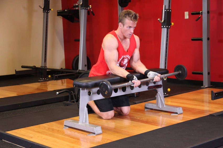 Palms-Up Barbell Wrist Curl Over A Bench, position 1 of 2