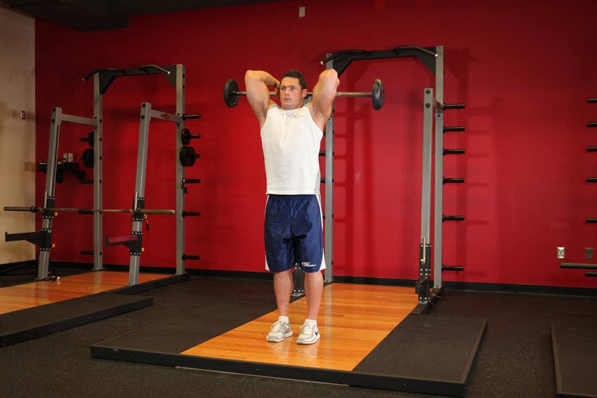 Standing Overhead Barbell Triceps Extension, position 1 of 2